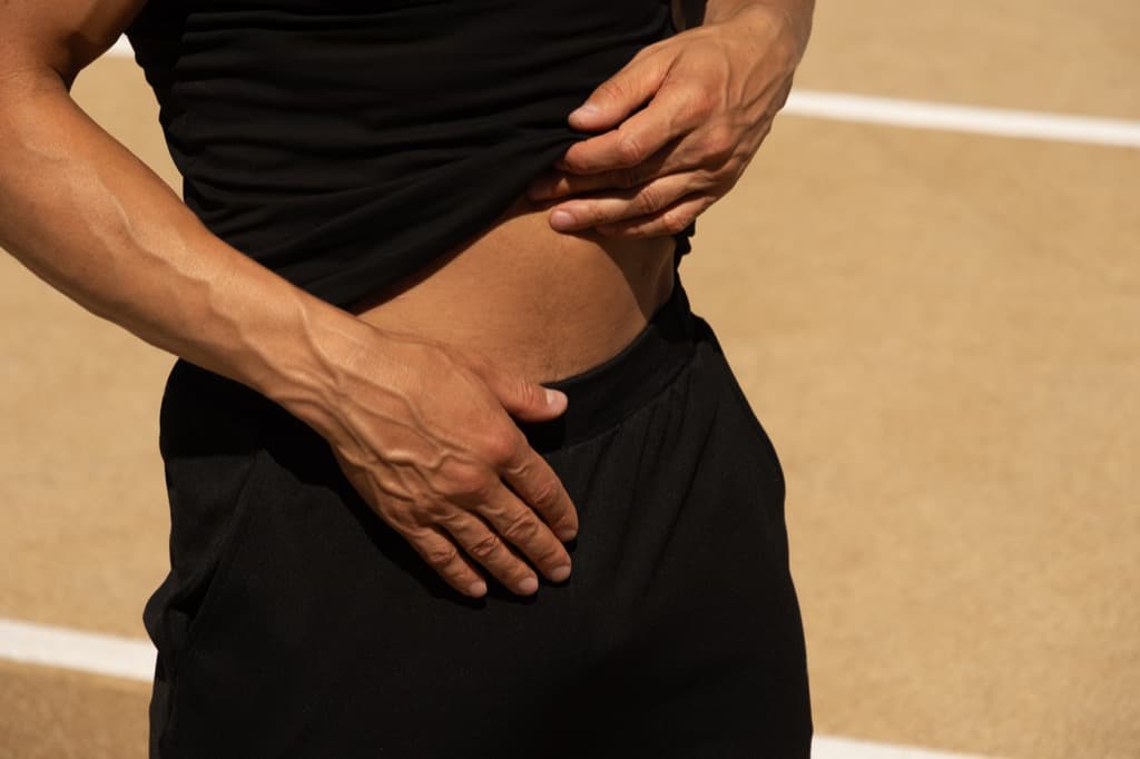 Runner holding their abdomen in pain